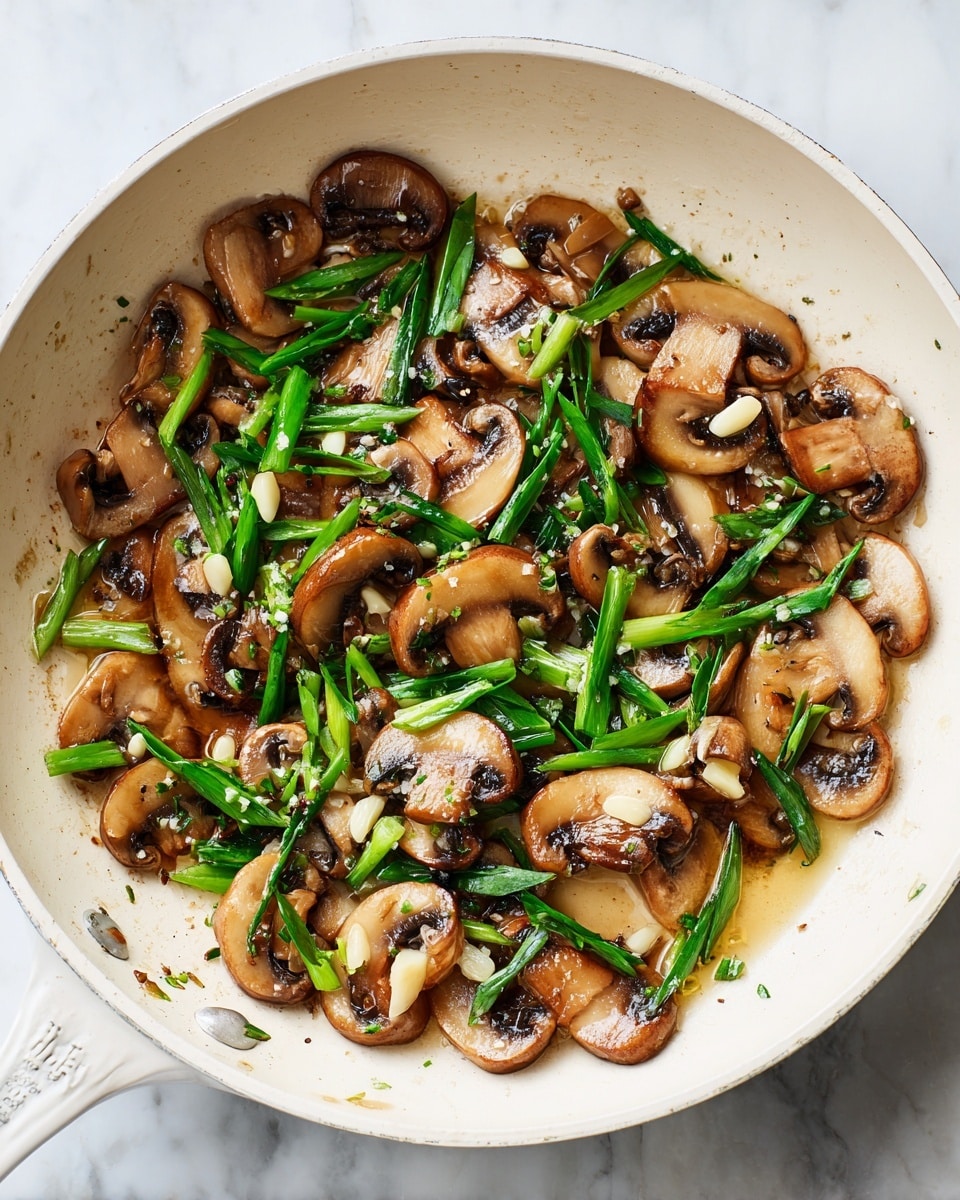 The image shows a white pan with sautéed mushroom slices and chopped green onions. The mushrooms have a light brown color and slightly shiny, soft texture. Small slices of light-colored garlic are mixed in, adding detail to the dish. The green onions are fresh and bright green, scattered evenly across the pan. A small amount of oil glistens under the ingredients, creating a slight reflection on the white surface. The scene is set on a white marbled background. photo taken with an iphone --ar 4:5 --v 7