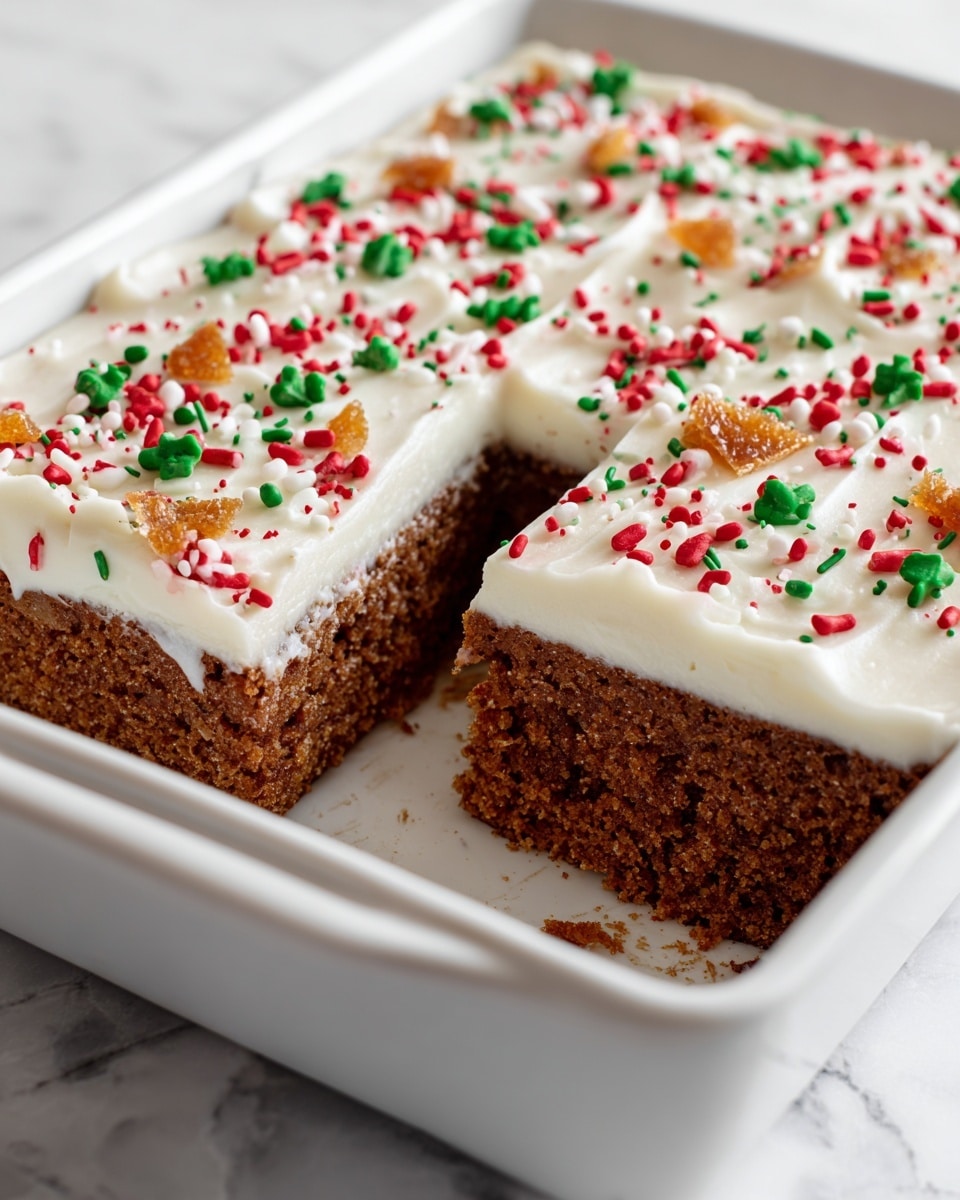 The image shows a close-up of a rectangular white baking dish with a gingerbread cake inside. The cake has two layers: a thick, dark brown gingerbread base with a soft texture, and on top a smooth layer of white frosting decorated with red, green, and white sprinkles along with small pieces of candied orange peel evenly spread. One square piece of the cake has been cut and removed from the dish, revealing the clean edges between the layers. The dish is placed on a white marbled surface. Photo taken with an iphone --ar 4:5 --v 7